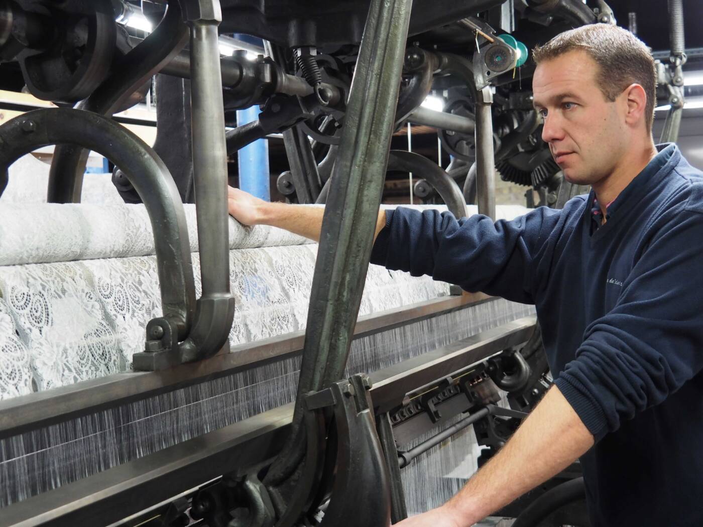 Tulliste à l'œuvre en train de superviser le fonctionnement d'une machine à tisser la dentelle.