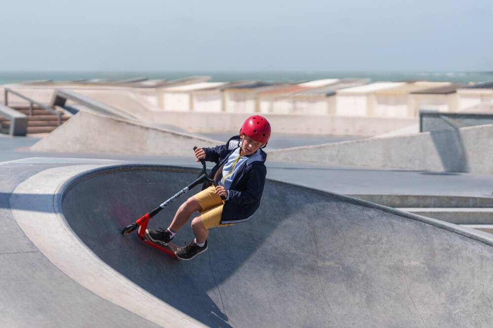 Un jeune garçon s'essaie aux sports de la glisse dans le skatepark à ciel ouvert de Calais LA Plage.