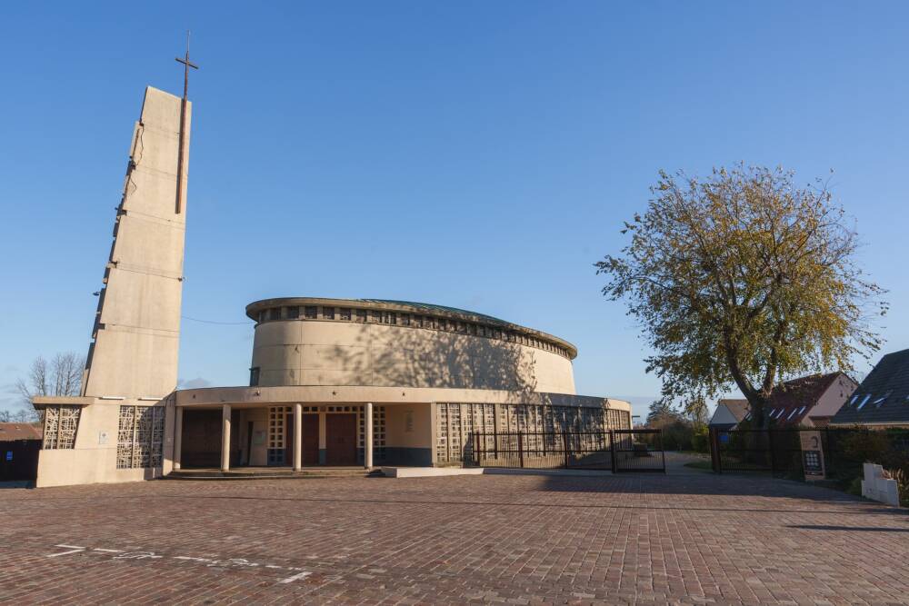 Photo de l'église emblématique à l'architecture bien particulière, portant le cachet de la reconstruction d'après seconde guerre mondiale.