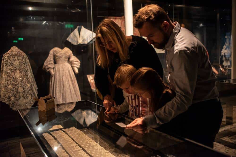 Une famille en proie à la curiosité pour l'histoire folle de la Dentelle de Calais et les salles dédiées de la Cité de la Dentelle et de la Mode.