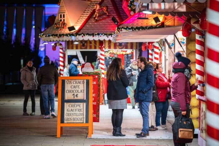 Vue des allées du Marché de Noël de Calais sur la Place d'Armes et ses chalets gourmands.