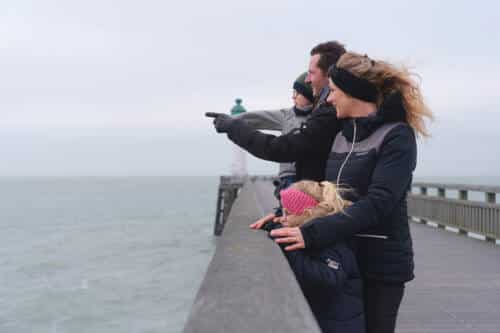 Une famille qui contemple le paysage hivernal depuis la jetée de la plage de Calais