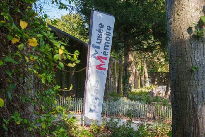 Vue de l'entrée du musée Mémoire et de la longueur du bunker dans le cadre verdoyant du parc Richelieu.