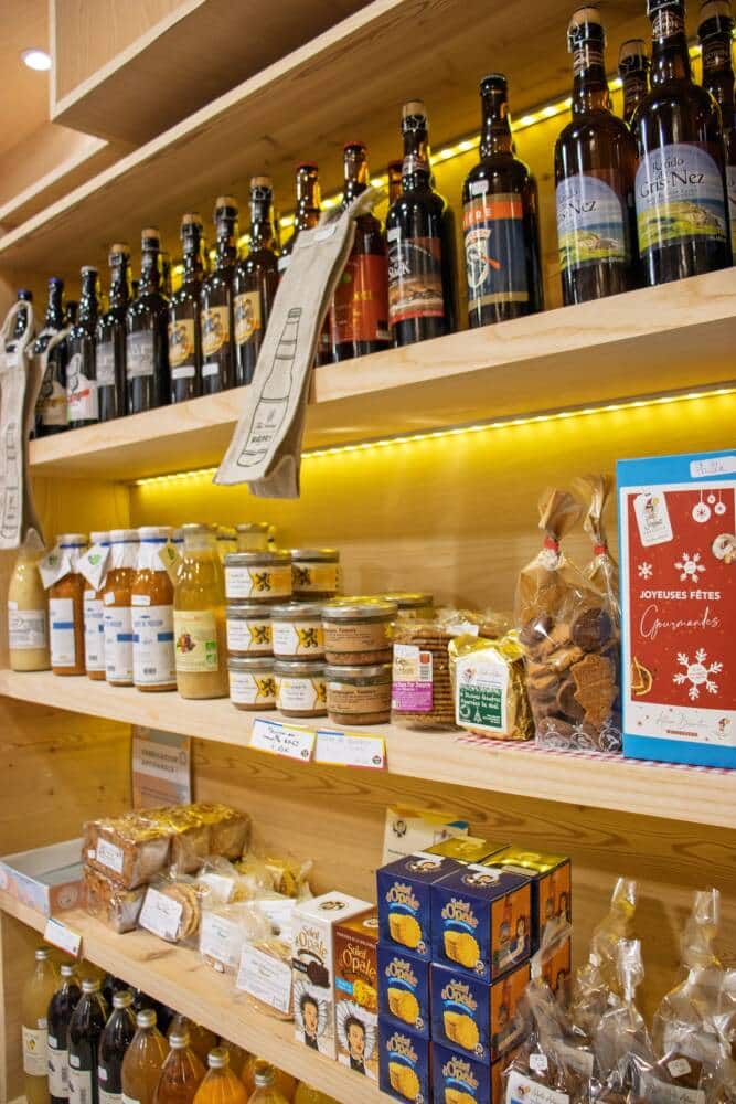 Description alt optimisée SEO : Rayon de produits du terroir au Comptoir de l’Îlot à Calais, présentant bières artisanales, biscuits locaux, jus de fruits, terrines et douceurs régionales. Une sélection gourmande et authentique, idéale pour des cadeaux festifs célébrant le savoir-faire culinaire de la région.